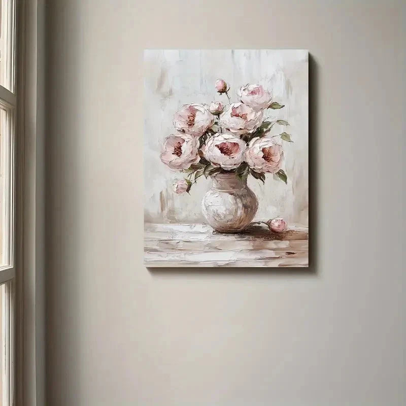 Painting of pink flowers in a vase on a wooden surface, hanging on a beige wall.
