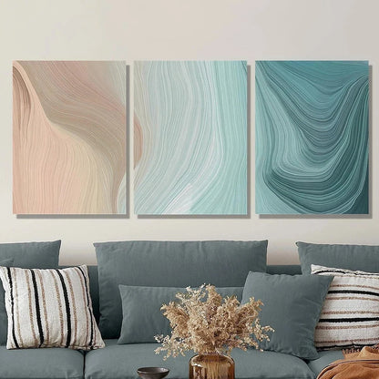 Three abstract wall art pieces above a sofa with decorative pillows and a vase.
