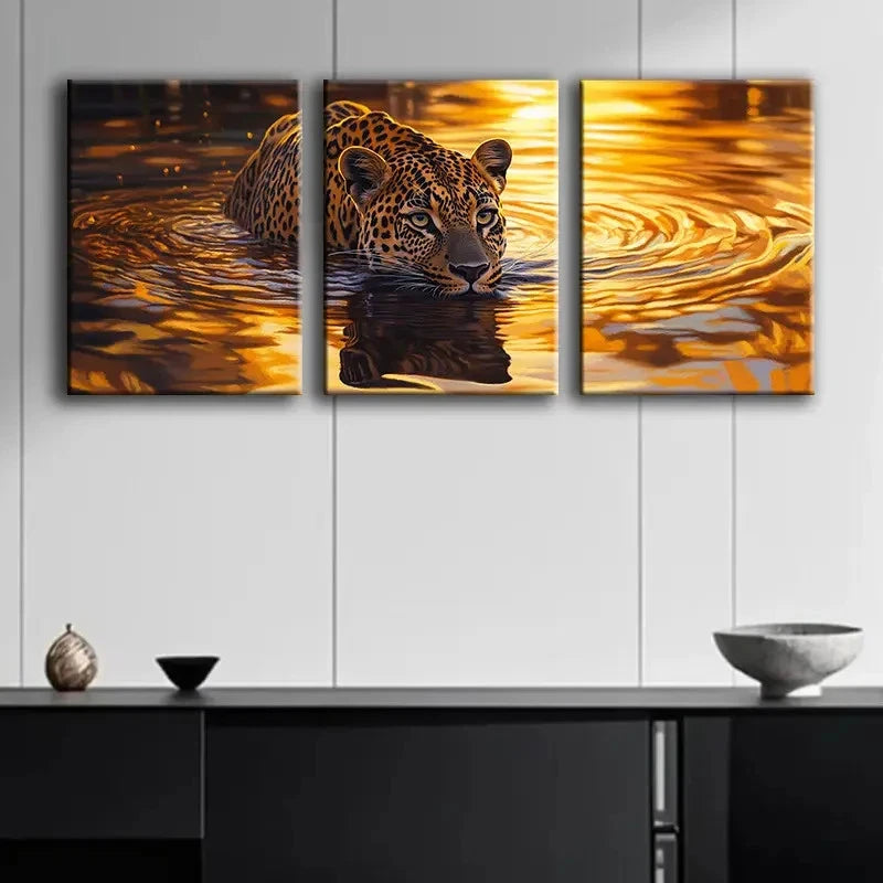 Three-panel canvas print of a leopard in water on a wall above a black cabinet.