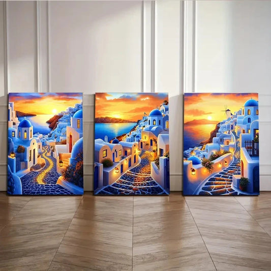 Three canvas prints of a blue Mediterranean village scene with a sunset.