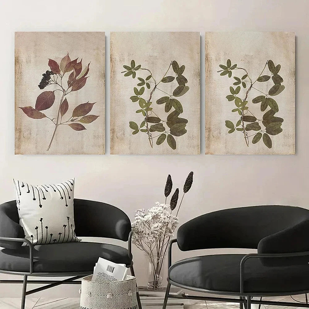 Three botanical wall art pieces above a modern black chair and table.