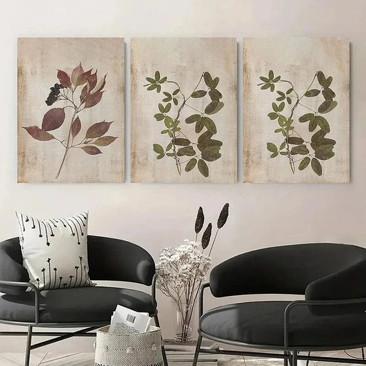 Three botanical wall art pieces above a modern black chair and table.