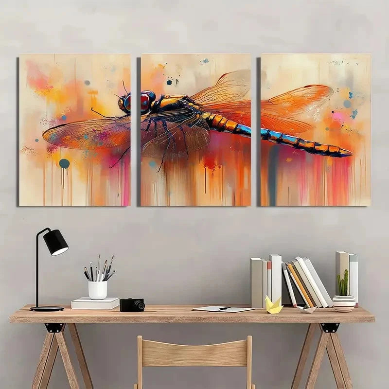 Three-panel abstract painting of a dragonfly on a wall above a wooden desk.