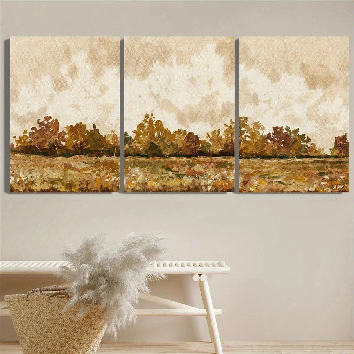 Three-panel wall art depicting a landscape with trees and clouds, mounted on a wall above a white bench.