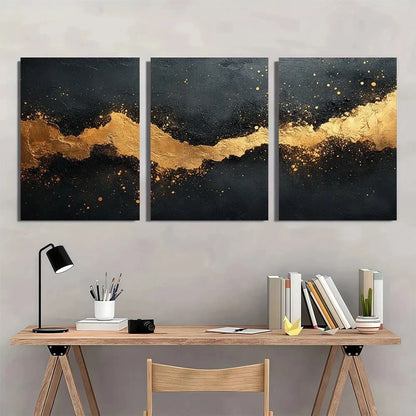 Three abstract art pieces with gold and black design on a wall above a wooden desk.