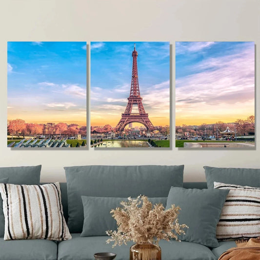 Three-panel wall art of the Eiffel Tower with a couch and decorative pillows in the foreground.