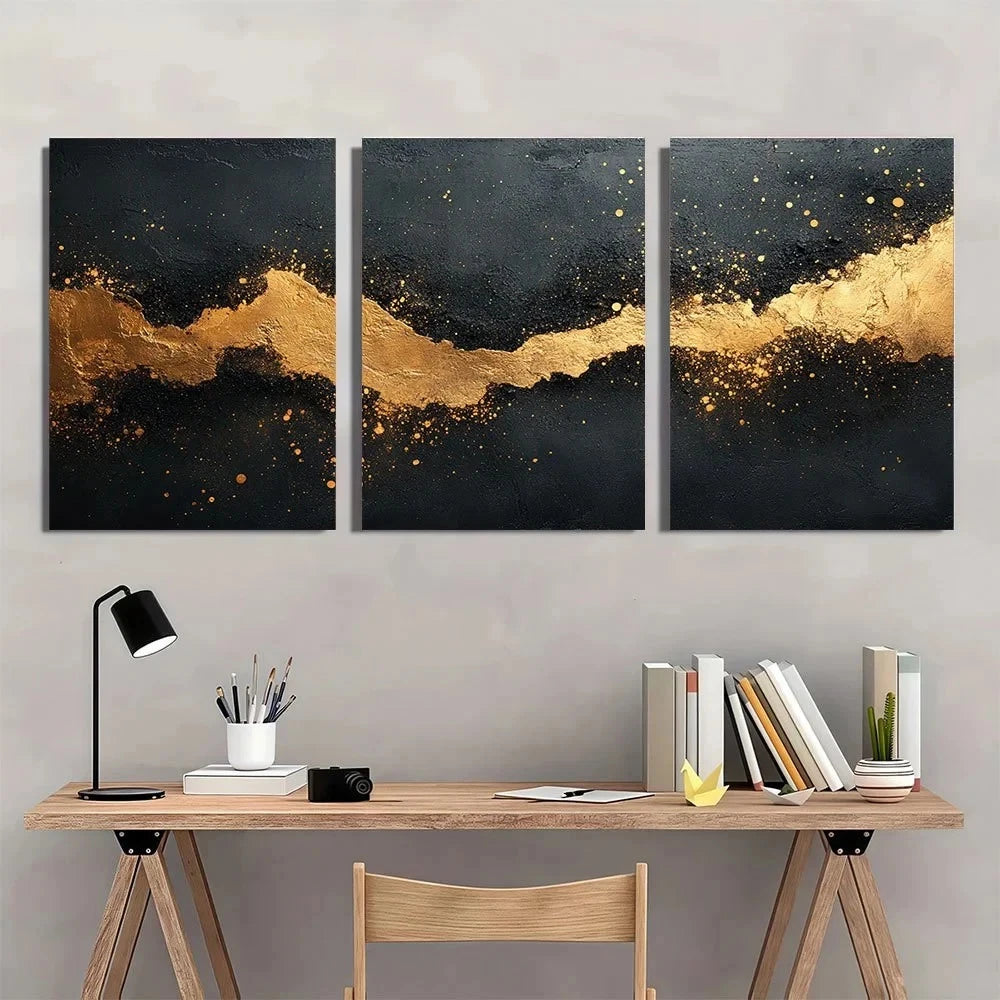 Three abstract art pieces with gold and black design on a wall above a wooden desk.