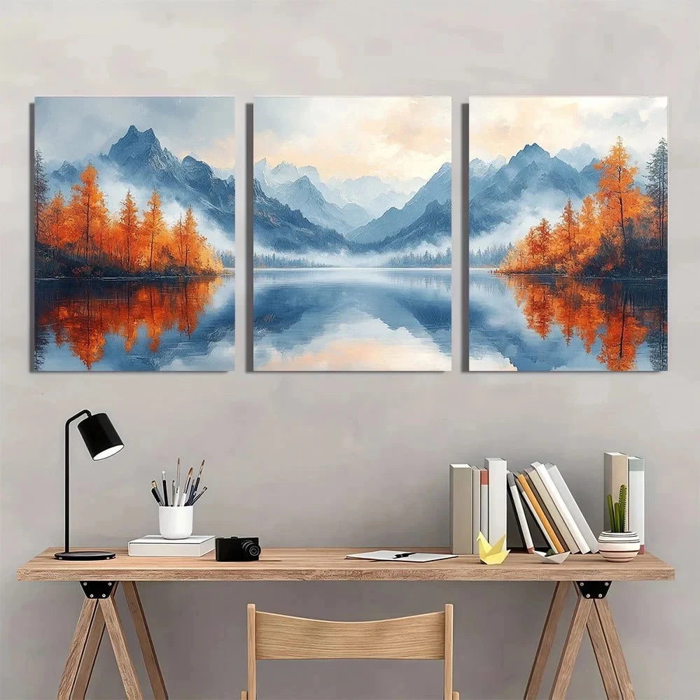Three-panel wall art of a mountain landscape with trees reflected in water, above a wooden desk.