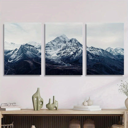 Three framed mountain landscape artworks on a wall above a wooden console table.
