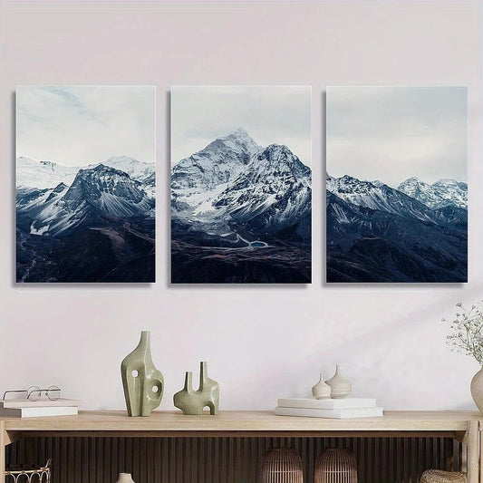 Three framed mountain landscape artworks on a wall above a wooden console table.