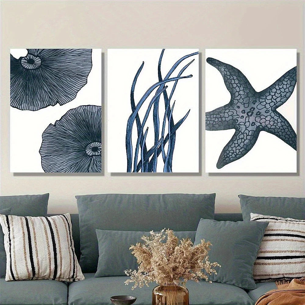 Set of three framed artworks with blue floral and starfish designs on a wall above a sofa.