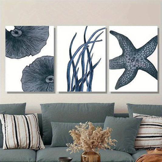 Set of three framed artworks with blue floral and starfish designs on a wall above a sofa.