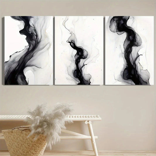 Three abstract black and white wall art pieces on a beige wall with a chair and basket in the foreground.