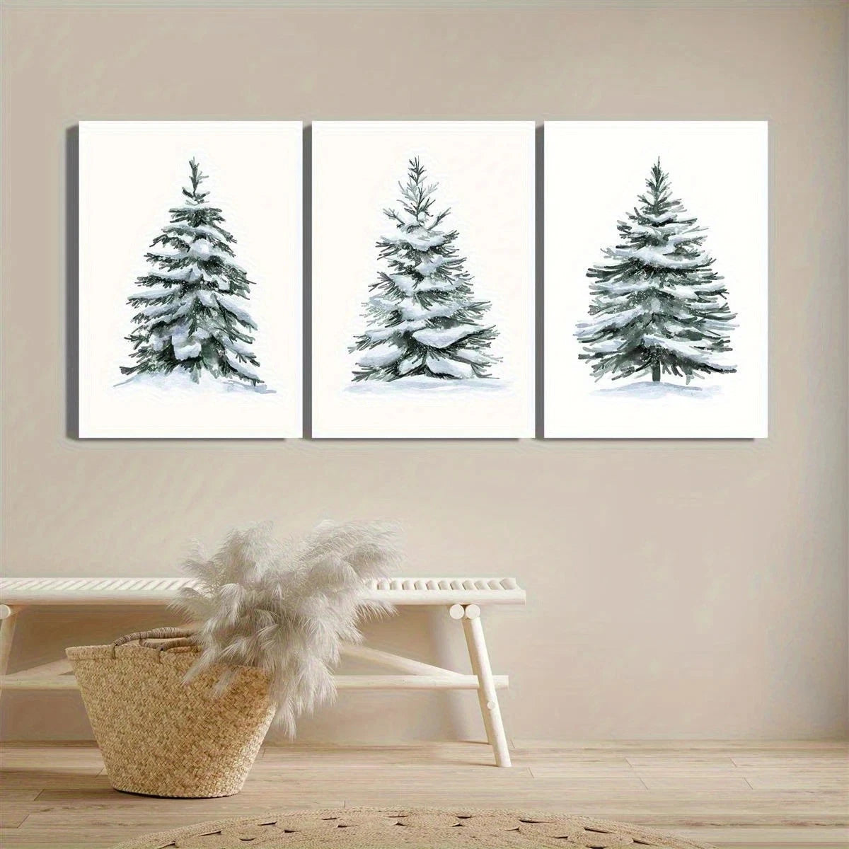 Three framed artworks of snow-covered trees on a beige wall above a white shelf with decorative items.