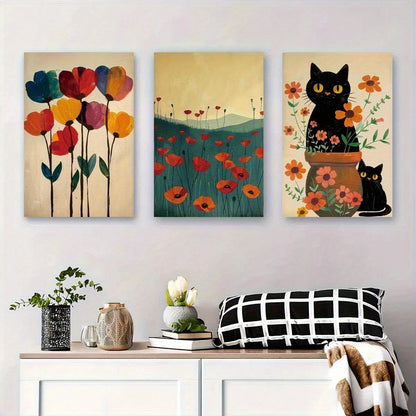 Three colorful paintings of flowers and cats on a wall above a white cabinet with decorative items.