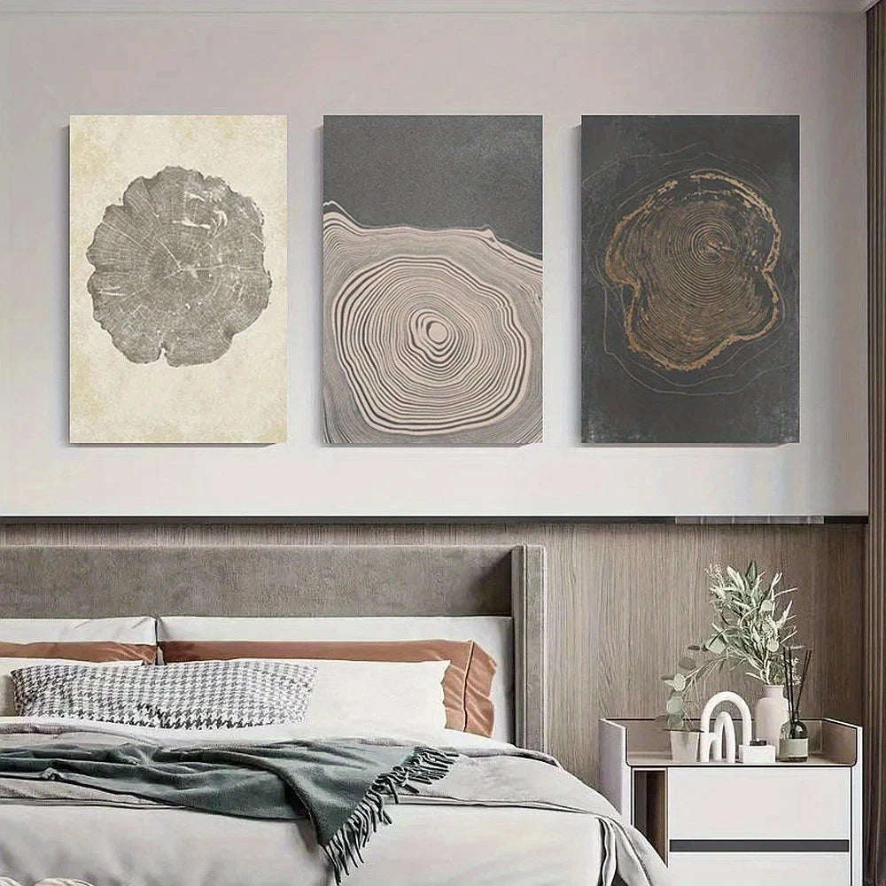 Three abstract wall art pieces above a bed in a bedroom setting.