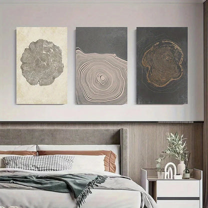 Three abstract wall art pieces above a bed in a bedroom setting.