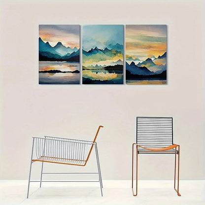 Three-panel wall art of a mountain landscape with two chairs below.