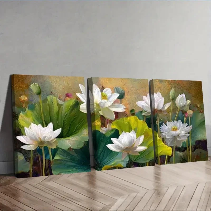 Set of three floral paintings with white flowers and green leaves on a wooden floor.