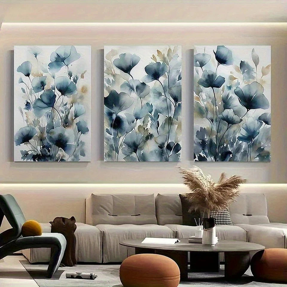 Three floral wall art pieces above a sofa in a living room.