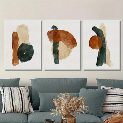 Three abstract art pieces on a wall above a sofa with decorative pillows and a vase.
