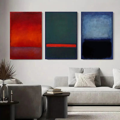 Three abstract paintings in red, blue, and gray above a sofa in a living room.