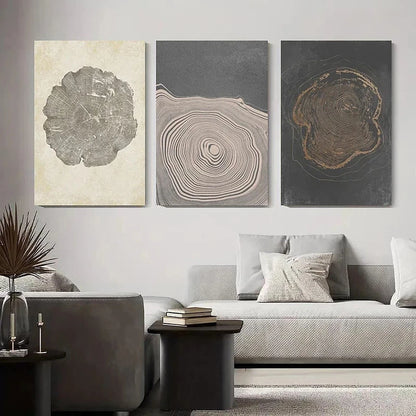 Three abstract wall art pieces on a gray wall above a sofa.