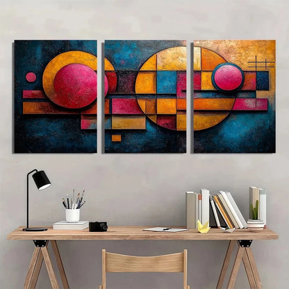 Abstract art triptych on a wall above a wooden desk with office supplies.