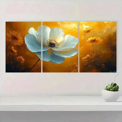 Triptych floral painting with a large white flower on a yellow background, displayed on a wall above a white shelf with a small plant.