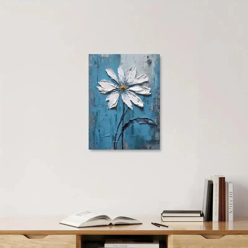 Painting of a white flower on a blue background hanging above a wooden shelf with books and an open book.