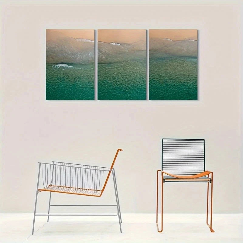 Three-panel wall art of a coastal scene with chairs below on a white background