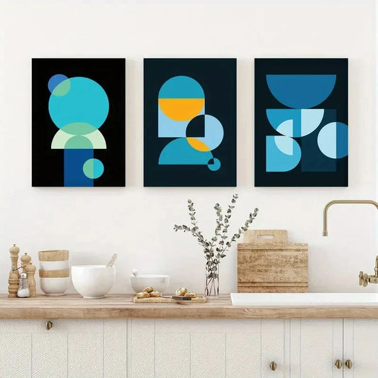 Three abstract art prints in a modern kitchen setting.