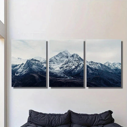 Three-panel wall art of a mountain landscape on a white wall above a sofa.