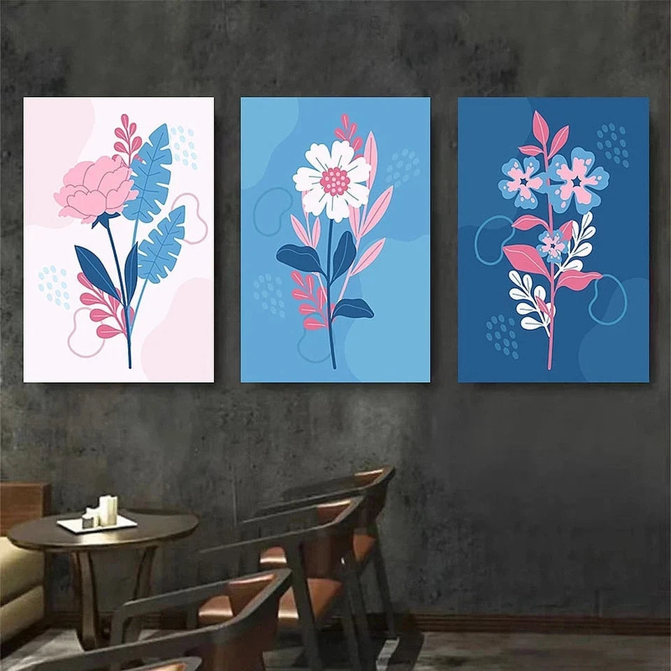Three floral wall art pieces on a dark wall above a dining table.