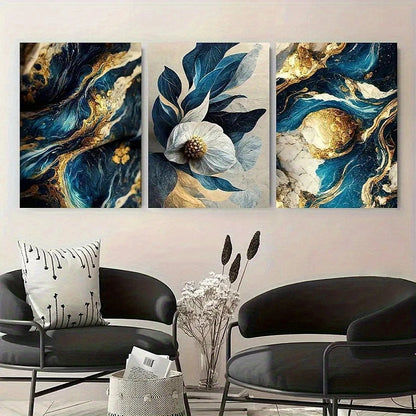 Three abstract art pieces with blue, gold, and white colors displayed above a modern living room setup.