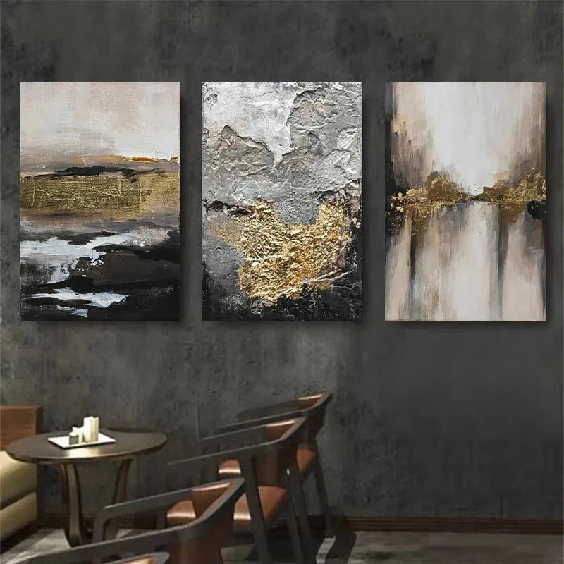 Three abstract art pieces with gold and black accents on a dark wall.