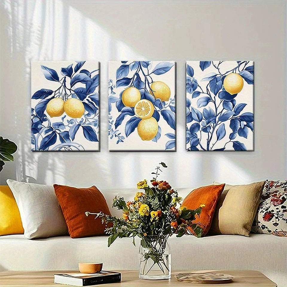 Three floral and lemon-themed wall art pieces on a wall above a sofa with decorative pillows.