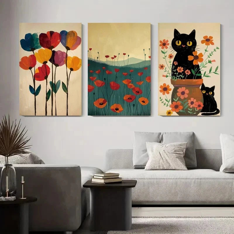 Three artistic wall hangings of flowers and cats in a living room setting.