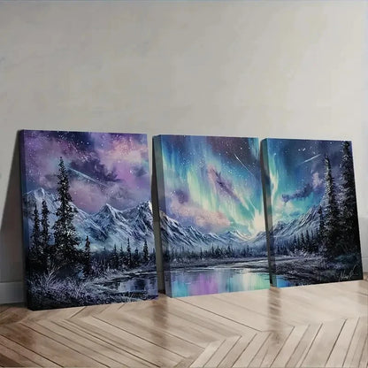 Three canvas prints of a mountain landscape with celestial elements on a wooden floor.